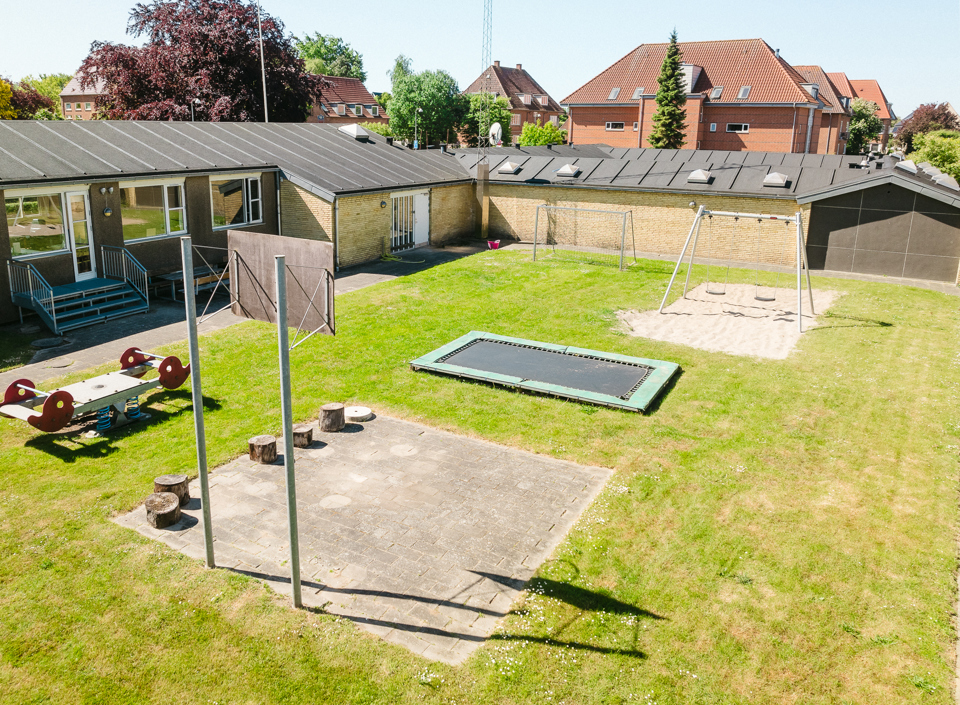 Trampolin, basket og gyngestativ i haven